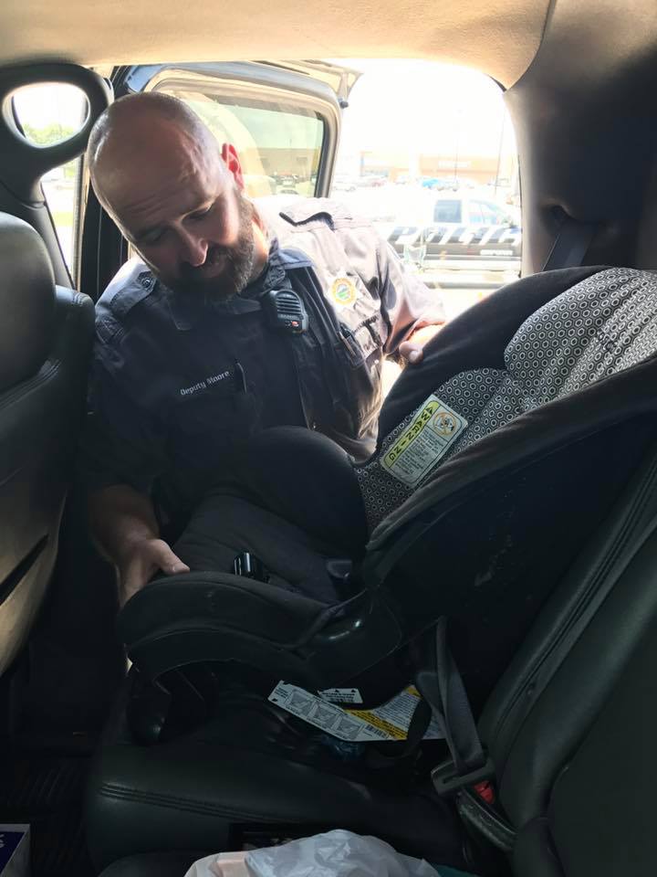 deputy checking car seat for safety